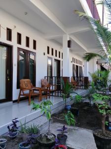 a courtyard with chairs and plants in a building at Vacation Inn Gili in Gili Trawangan