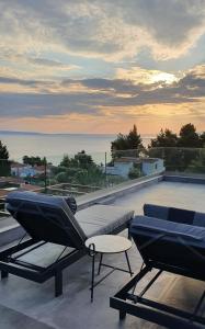 two lounge chairs and a table on a roof at Palladium Hotel in Kriopigi