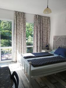 a bedroom with two beds and two windows at Blue summer villa in Sinemorets