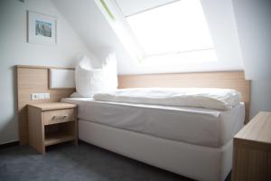 1 dormitorio con cama blanca y ventana en Alpha & Omega Hotel en Stuttgart