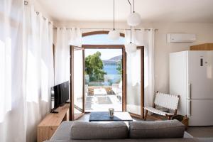 a living room with a couch and a television at Vista Portolago Villas in Lakkíon