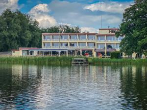 ein großes Gebäude neben einem Wasserkörper in der Unterkunft Seehotel Schwanenhof in Mölln