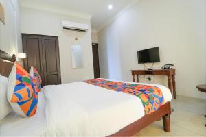 a bedroom with a white bed and a television at FabHotel K9 Villa in Ludhiana