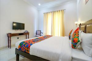 a hotel room with a bed and a television at FabHotel K9 Villa in Ludhiana