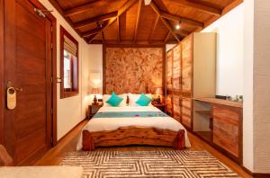 a bedroom with a large bed with a wooden headboard at Island Luxury Boutique Hotel - Fulhadhoo in Fulhadhoo