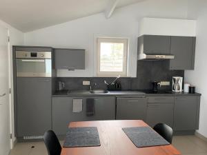 a kitchen with a wooden table and a dining room at Westerhuisje in Middelkerke