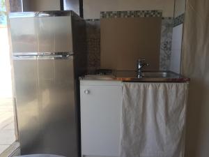 a small kitchen with a sink and a refrigerator at un nid en provence in Coudoux