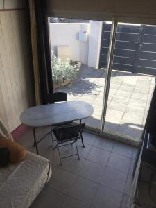 a table and a chair in a room with a window at un nid en provence in Coudoux