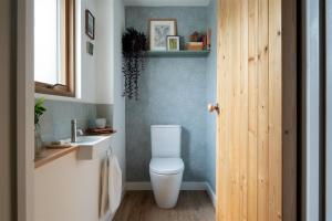 uma casa de banho com um WC branco e um lavatório. em Sunnybrook - A luxurious Carbon Neutral House close to beach, Shaldon em Shaldon