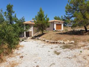 uma pequena casa numa colina com uma estrada de terra em Villa Istra em Divšići