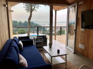 a living room with a blue couch and a table at Cabañas Rias Baixas in A Pobra do Caramiñal