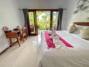 une chambre avec un lit, un bureau et une table dans l'établissement Rumah Diyah, à Amed