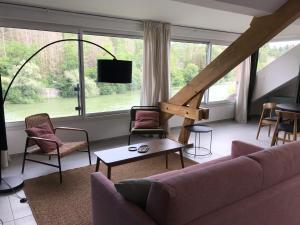 a living room with a couch and chairs and a large window at Les 4 gites de la Saisse in Pont-de-Poitte