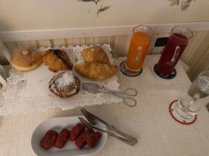 stół z talerzem wypieków i kieliszkami soku pomarańczowego w obiekcie Bed & Breakfast De Nittis w mieście Barletta +37 zdjęć