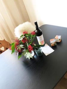 uma garrafa de vinho e flores sobre uma mesa em Apartmán Strnadovy Boudy em Železná Ruda