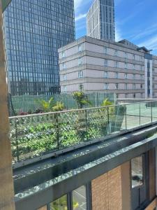 a balcony with a view of a city with buildings at Luxury 9ine PENTHOUSE WITH GARDEN & JACUZZI in Birmingham