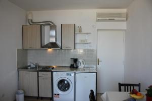 a kitchen with a washing machine and a washer at Studio Tamara in Dubrovnik