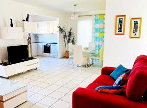 sala de estar con sofá rojo y cocina en My sweet home en Pafos