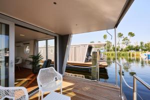 a house with a boat on the water at Luxurious Houseboat - Zen in Dinteloord