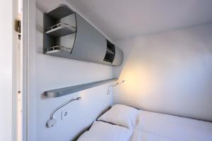 a small room with a bed and a sink at Luxurious Houseboat - Zen in Dinteloord