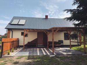 a house with a solar roof and a patio at Domek Zuza Nielisz in Nielisz