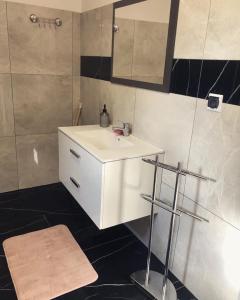 La salle de bains est pourvue d'un lavabo blanc et d'un miroir. dans l'établissement Domek Zuza Nielisz, à Nielisz
