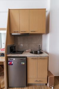 a small kitchen with a sink and a refrigerator at Novelrooms in Paralia Katerinis