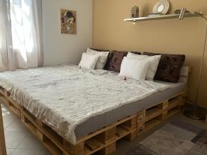 un grande letto in legno in una camera dotata di di Karneol Apartman a Balatonfenyves