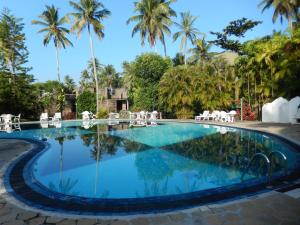 una piscina en un complejo con palmeras en el fondo en Villa Ranmenika, en Ahungalla