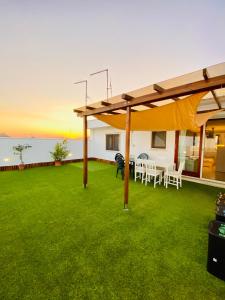 a patio with a table and chairs on the grass at Lucky’s house in Noicattaro