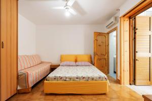 una piccola camera con letto e divano di Bilocale Dimora Punta della Suina a Marina di Mancaversa