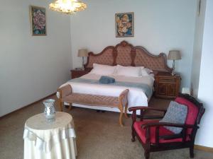 a bedroom with a large bed and a chair at Naleli Guest House in Selomas