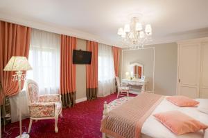 a room with a bed, chair, lamp and a table at Hotel Usadba in Smolensk