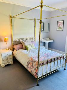 a bedroom with a canopy bed and a sink at Beautiful Private 2 Bedroom Suite in Mansion Home with Free Parking in Brighton & Hove