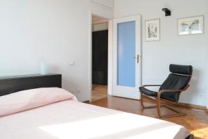 a bedroom with a bed and a black chair at CASA KIKA Comoda, Luminosa e Accogliente in Milan