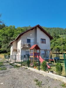 a house with a playground in front of it at Apartman „Škobić” in Višegrad