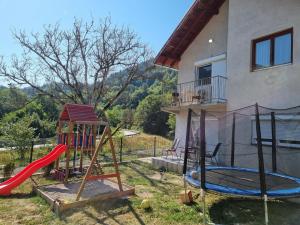 une maison avec une aire de jeux dotée d'un toboggan dans l'établissement Apartman „Škobić”, à Višegrad