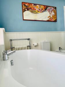 La salle de bains est pourvue d'un lavabo et d'une peinture murale. dans l'établissement Beautiful Private 2 Bedroom Suite in Mansion Home with Free Parking, à Brighton et Hove