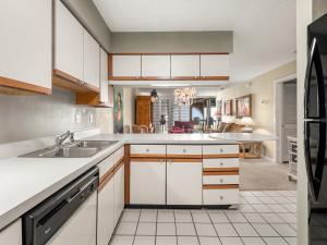 a kitchen with white cabinets and a sink at Hibiscus 301-A, 2 Bedrooms, Ocean Front, 3 Pools, Sleeps 6, Pet Friendly in St. Augustine