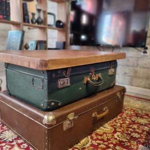 two suitcases stacked on top of each other on a rug at La cabane des sorciers in Liévin