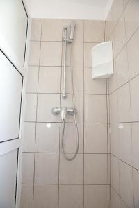 La salle de bains est pourvue d'une douche avec un pommeau de douche. dans l'établissement Apartments Lepur, à Vodice