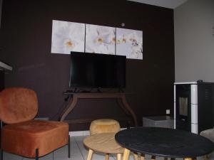 a living room with a table and chairs and a tv at Gite "Vue Sur La Frontiere" in Heining-lès-Bouzonville