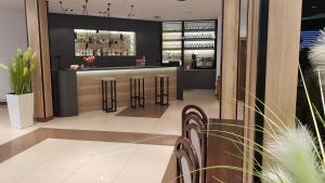 a restaurant with a bar with stools in a lobby at Hotel Zimnik Luksus Natury Spa & Wellness in Szczyrk