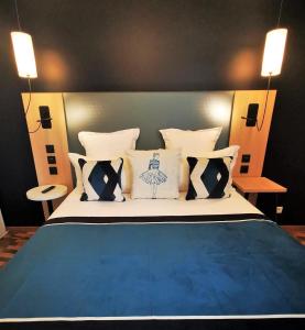 a bedroom with a blue and white bed with pillows at Residhome Asnieres in Asnières-sur-Seine