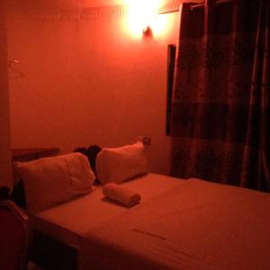 1 dormitorio con 1 cama con sábanas y almohadas blancas en Macarela Inn, en Sanya Juu