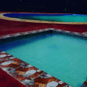 a swimming pool with blue water and rocks in it at Macarela Inn in Sanya Juu