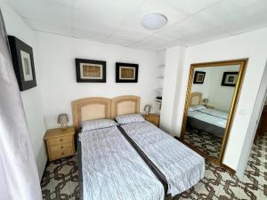 een slaapkamer met een bed en een spiegel bij Mirror Apartment Gandia in Gandía