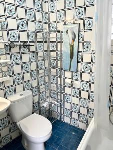 baño con aseo y pared de azulejos en Mirror Apartment Gandia en Gandía