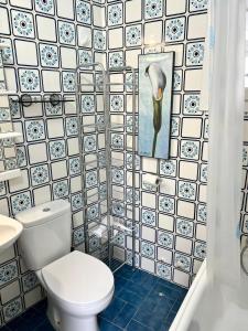 a bathroom with a toilet and a tile wall at Mirror Apartment Gandia in Gandía