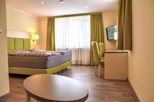 une chambre d'hôtel avec un lit et une table dans l'établissement Landgasthof Krone, à Offingen